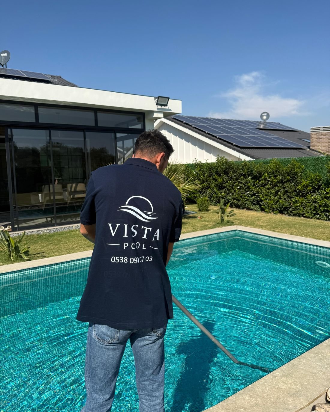 Vista Pool teknisyeni villa havuzunda dip süpürgesiyle temizlik yaparken